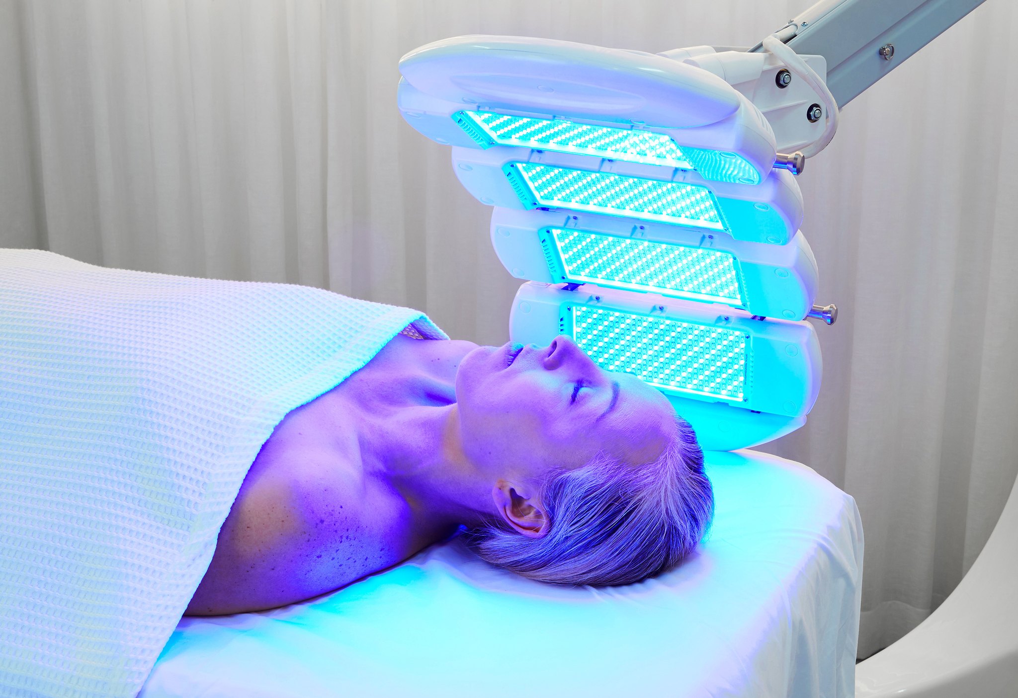 woman using the dermalux LED phototherapy machine for skincare vie aesthetics